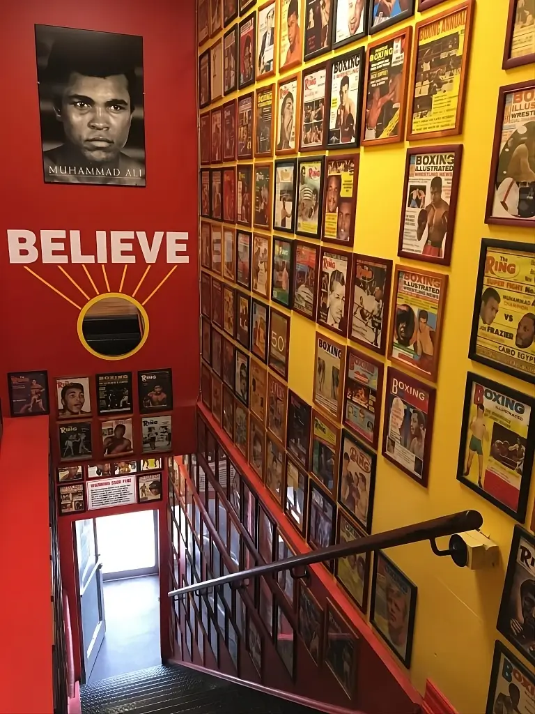 Interior of Bloor Street Fitness & Boxing in Toronto featuring a Muhammad Ali poster and a wall covered with classic boxing magazine covers.