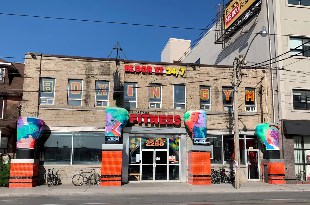 Front view of Bloor Street Fitness & Boxing gym in Toronto with colorful painted boxing gloves and bright signage.